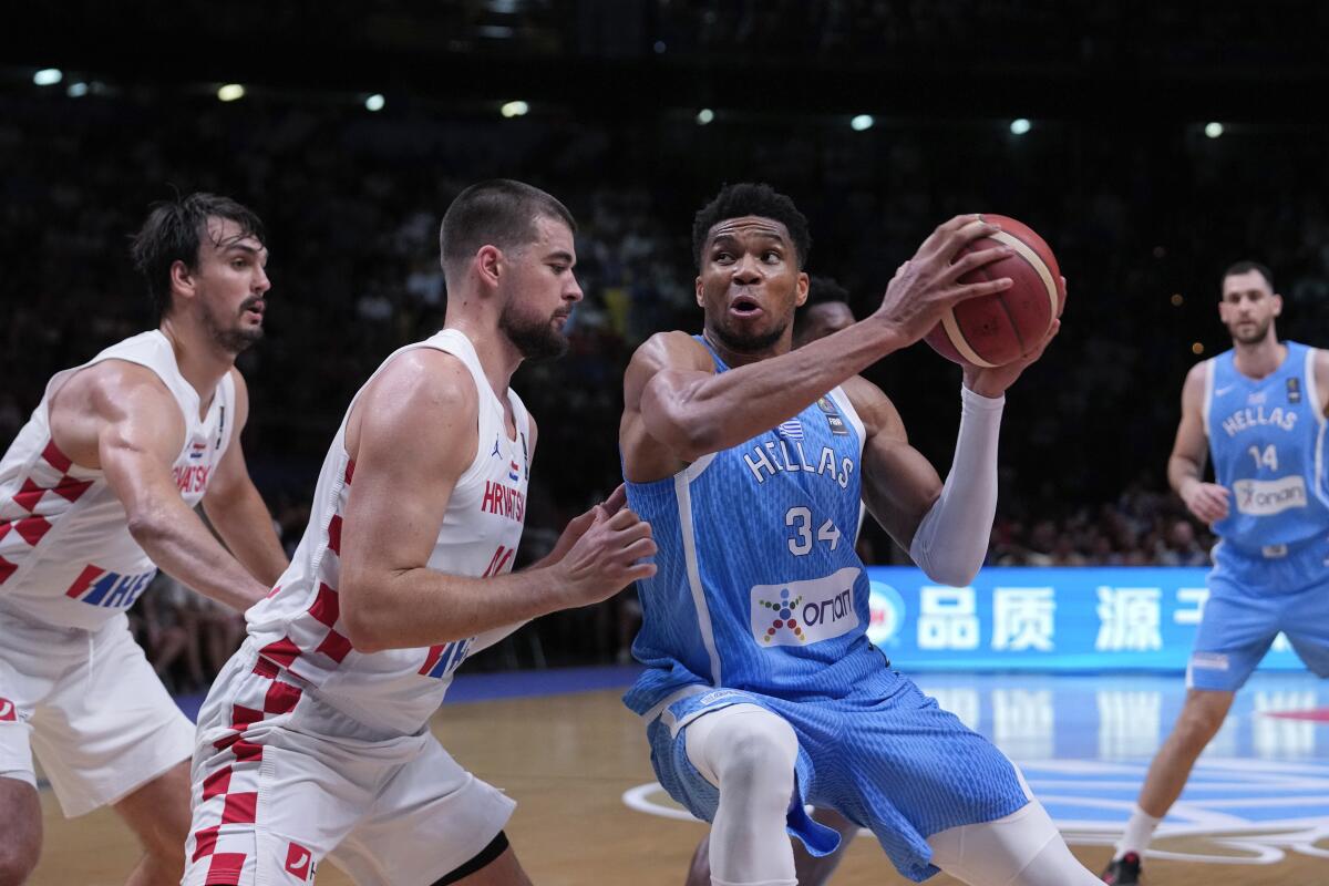 Greece's Giannis Antetokounmpo, right, is defended by Croatia's Ivica Zubac during an Olympic basketball qualifying game.