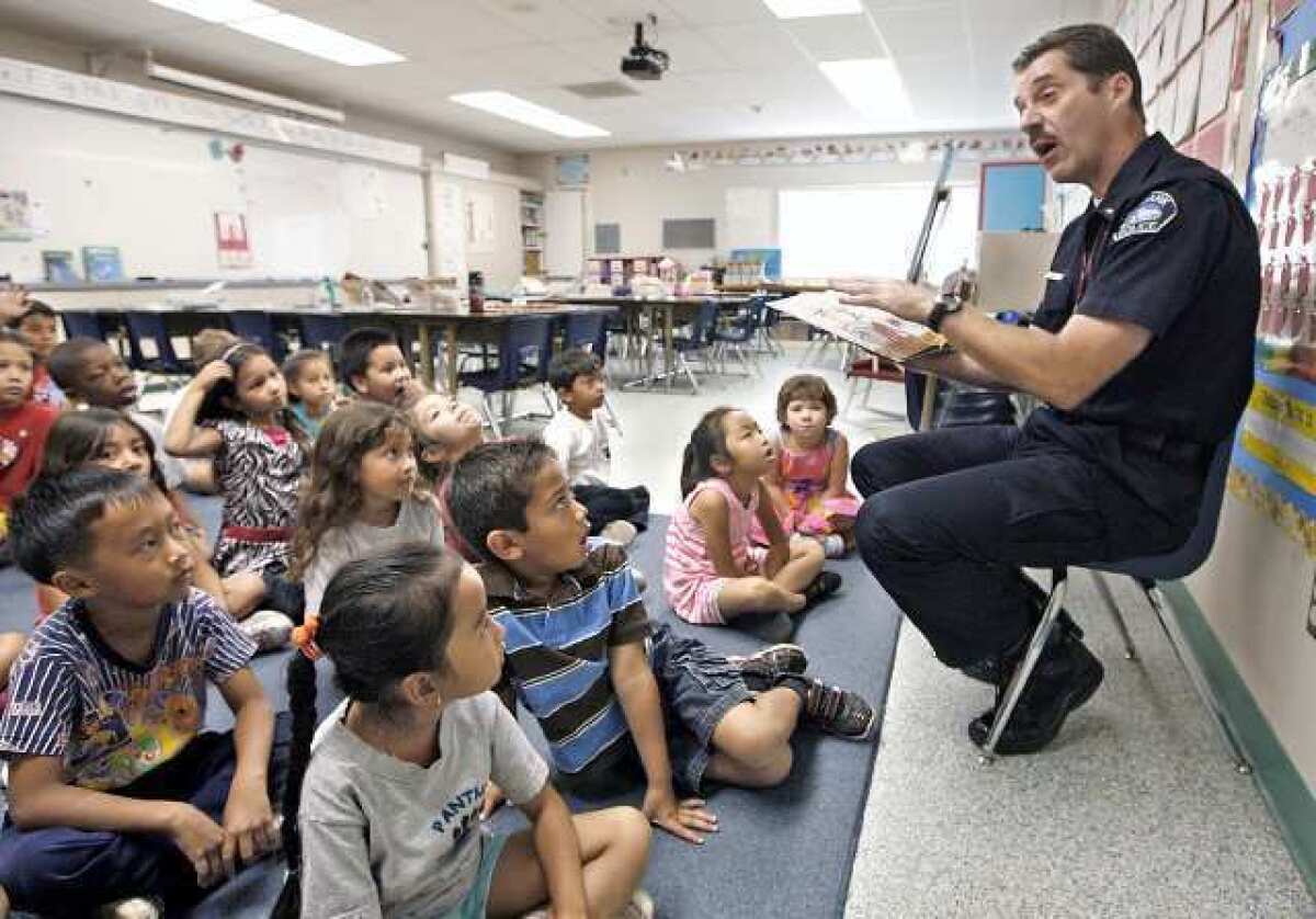 Burbank Police Lt. John Dilibert reads Eric Carle's A House for Hermit Crab to a group of first graders at Providence Elementary School on Friday, September 28, 2012 as part of the school's Literature Week.