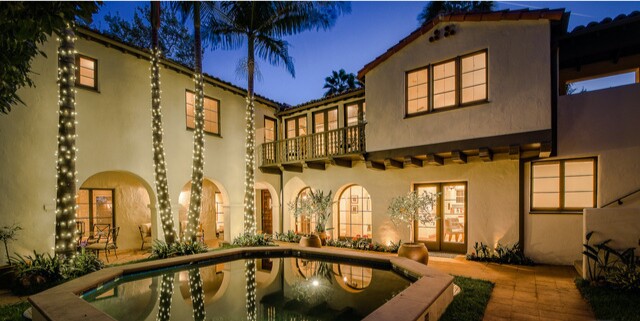 Built in 1929, the Spanish-style home opens to a romantic courtyard with palm trees and a pool.
