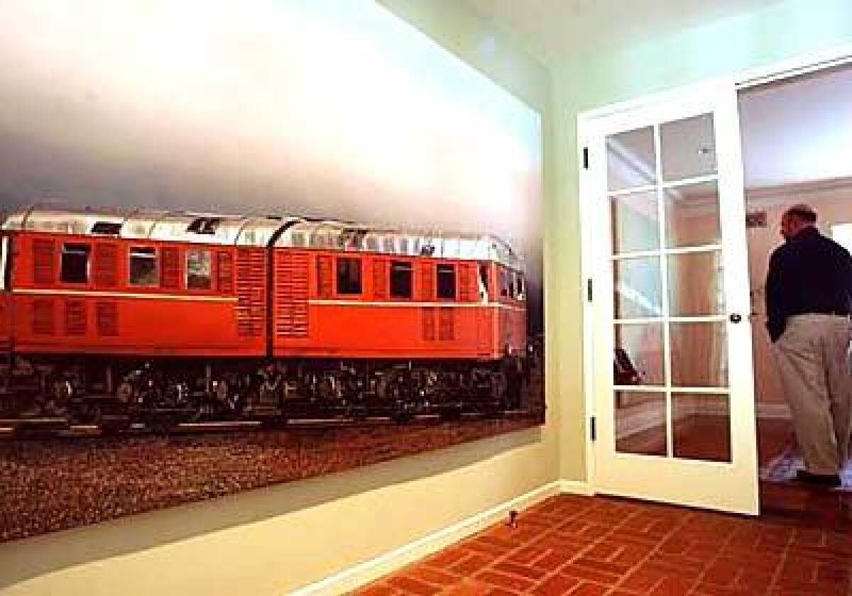 In the den, German artist Dirk Skrebers Untitled painting depicts a lifelike image of a train in a mix of media.