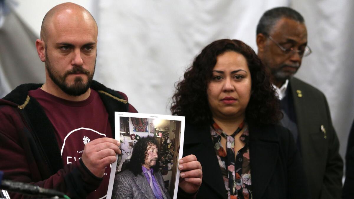 David Puthoff holds a photo of street vendor Pedro Daniel Reyes during a news conference Wednesday with Gilma Almendarez, Reyes’ stepdaughter, and Councilman Curren Price. A reward for information leading to the arrest of those who attacked Reyes has been offered.