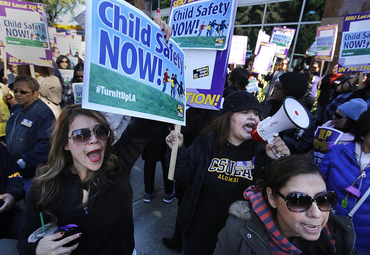 Natalie Guerra, left, and Veronica Luna (with bullhorn), both emergency response investigators for the Department of Children and Family Services, protest with other striking Los Angeles County children's social workers outside the El Monte field office of L.A. County Supervisor Gloria Molina...