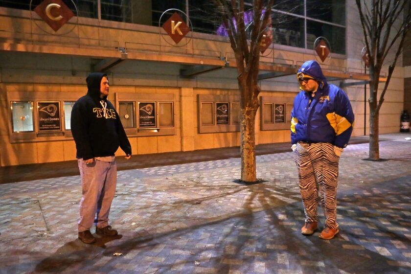 Two St. Louis Rams fans stand outside the Edward Jones Dome on Jan. 12. The NFL on Tuesday approved the Rams' relocation to Los Angeles.