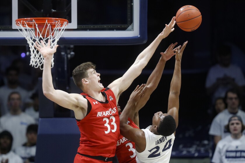 FILE - In this Dec. 7, 2019, file photo, Cincinnati's Chris Vogt (33) blocks a shot by Xavier's KyKy Tandy (24) during the first half of an NCAA college basketball game in Cincinnati. Wisconsin has announced the addition of 7-foot-1 center and Cincinnati transfer Chris Vogt Vogt started 50 games at Cincinnati. He averaged 5 points, 3.5 rebounds and 1.1 blocks and 19.4 minutes last season. (AP Photo/John Minchillo, File)