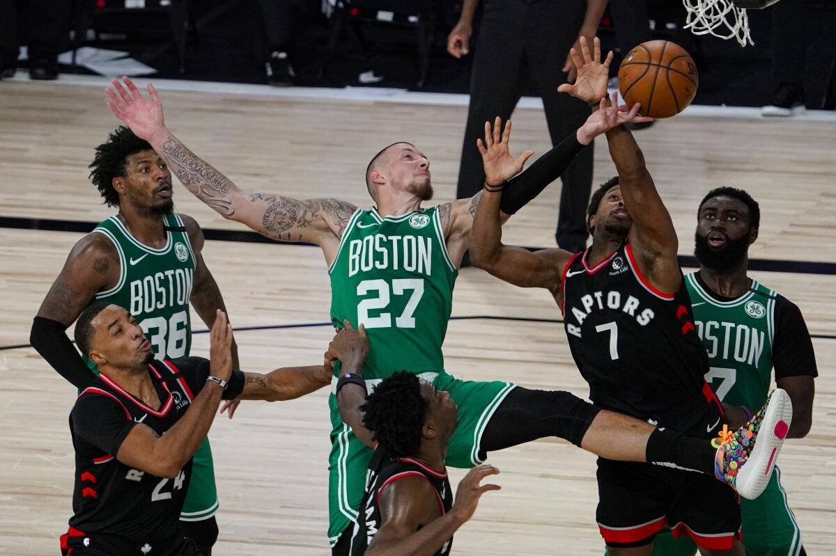 Boston Celtics center Daniel Theis tries to shoot over Toronto Raptors guard Kyle Lowry.
