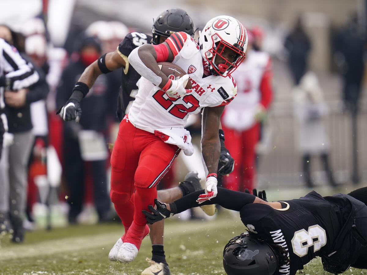 FILE - In this Dec. 12, 2020, file photo, Utah running back Ty Jordan avoids Colorado safety Derrion Rakestraw for a long gain in the second half of an NCAA college football game in Boulder, Colo. Utah opens the season against Weber State on Thursday. (AP Photo/David Zalubowski, File)