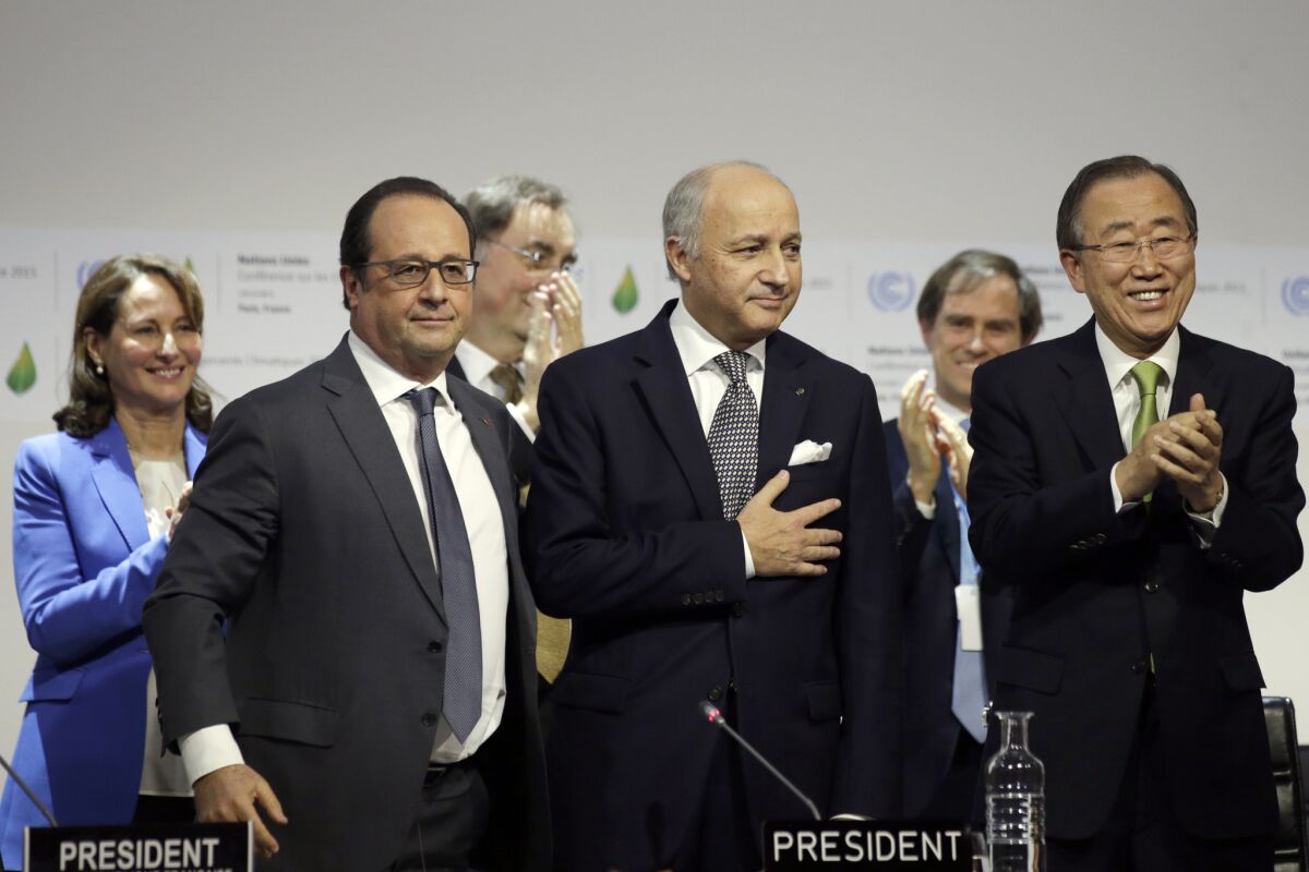 French Foreign Minister Laurent Fabius puts his hand over his heart after his speech at Le Bourget, outside Paris. Flanking him are French President Francois Hollande, left, and U.N. Secretary-General Ban Ki-moon.