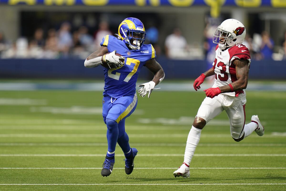 Rams running back Darrell Henderson, left, sprints past Arizona Cardinals cornerback Robert Alford.