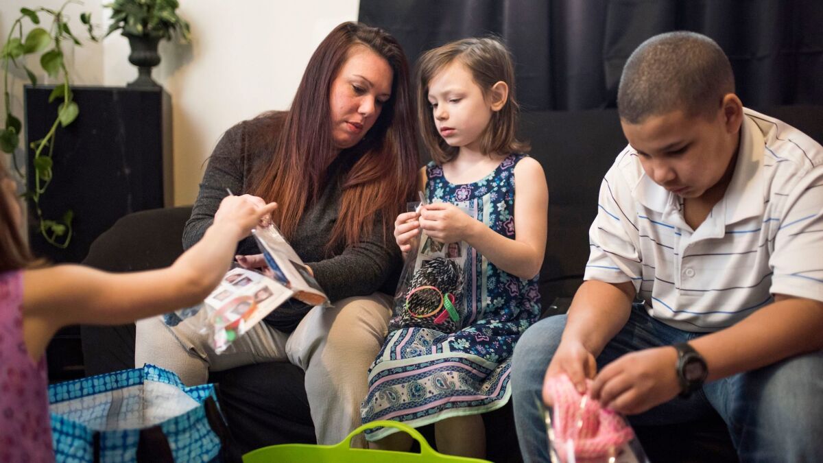 Rebecca Hendricks makes influenza awareness kits with her children, Breanna Taylor, Audreana Taylor and Ethan Richardson, at their home in Tacoma, Wash.