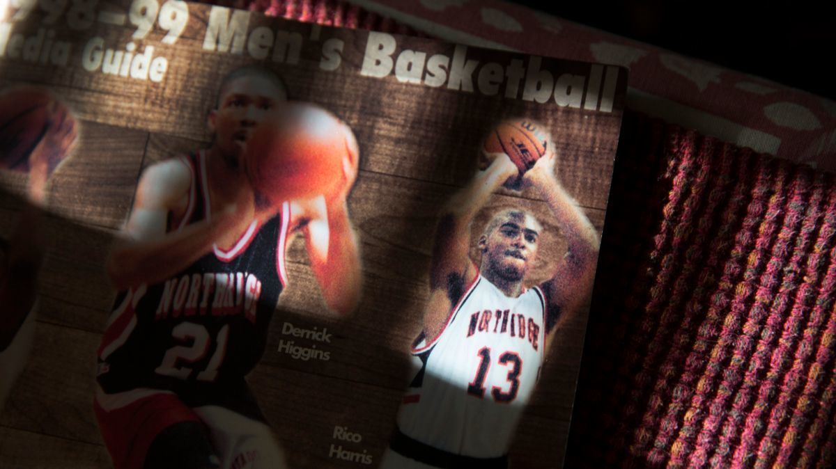 Margaret Fernandez displays a Cal State Northridge basketball media guide featuring her son, Rico Harris.