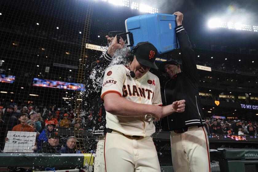 Logan Webb de los Gigantes de San Francisco es bañado con un agua por sus compañeros tras la victoria ante los Atléticos de Oakland el miércoles 31 de julio del 2024. (AP Foto/Godofredo A. Vásquez)