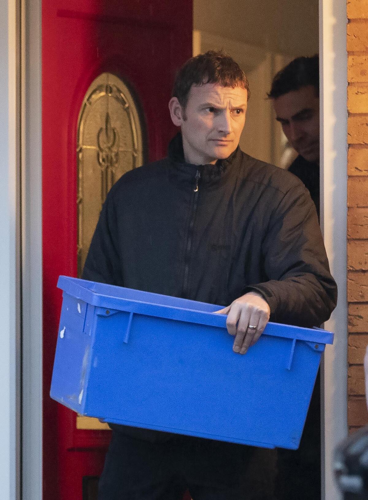 A police officer carrying an evidence box