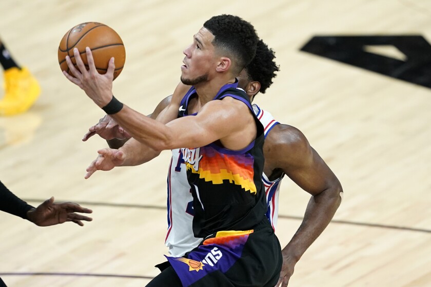Phoenix Suns guard Devin Booker (1) shoots against Philadelphia 76ers during the second half of an NBA basketball game, Saturday, Feb. 13, 2021, in Phoenix.(AP Photo/Matt York)