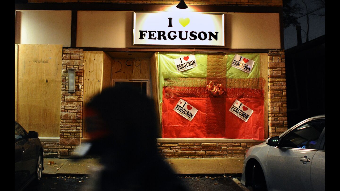 The "I love Ferguson" store is boarded with plywood against the unrest that has plagued the city since August. But volunteer workers have covered the store to look like a Christmas present instead.