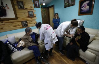Dr. Tania Díaz Bravo, á esquerda, revisa os signos vitais De Esther Canales Cruz, 78, mentres que a enfermeira Ana Arteaga dá a Maria Cruz Hernández, 81, un recibo que mostra que xa aplicou a primeira dose da vacina de Astrazen ECA contra o Coronavirus, o xoves 18 de febreiro de 2021, no distrito de Cuajimalpa nos arredores da Cidade de México. (AP Photo / Rebecca Blackwell)