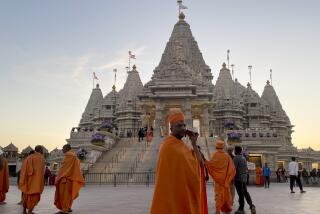 Monks in saffron robes walk in front of the BAPS Swaminarayan Akshardham, the largest Hindu temple outside India in the modern era, on Wednesday Oct. 4, 2023, in Robbinsville, N.J. The temple was partly built using marble from Italy and limestone from Bulgaria hand-carved by artisans in India and shipped to New Jersey. (AP Photo/Luis Andres Henao)