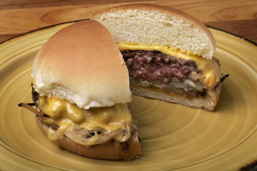 Onion-entangled grilled burger with American cheese.