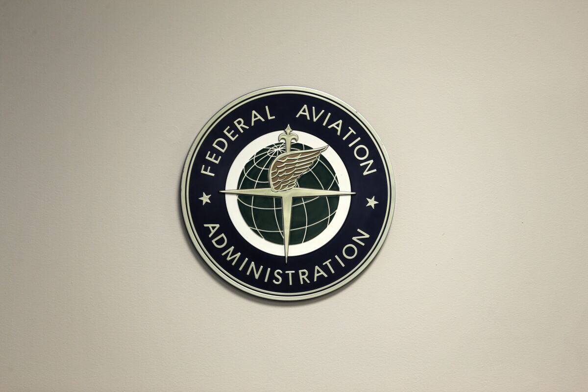 FILE - A Federal Aviation Administration sign hangs in the tower at John F. Kennedy International Airport in New York, March 16, 2017. Congress is taking up key aviation legislation just after close calls between planes at airports in New York and Texas. A House committee held the first hearing Tuesday, Feb. 7, 2023, on legislation that will govern the Federal Aviation Administration. (AP Photo/Seth Wenig, File)