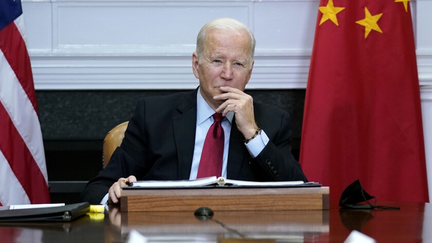 FILE - President Joe Biden listens as he meets virtually with Chinese President Xi Jinping from the Roosevelt Room of the White House in Washington,Nov. 15, 2021. The Biden administration announced on Thursday that it is levying new sanctions against several Chinese biotech and surveillance companies operating out of Xinjiang province, casting another shot at Beijing over human rights abuses against Uyghurs in western China. (AP Photo/Susan Walsh, File)