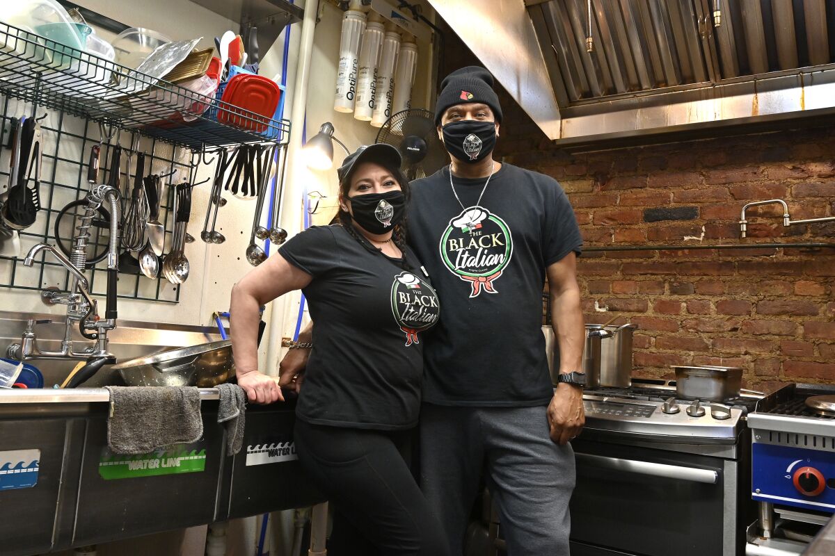 Owners of The Black Italian restaurant and catering service, Paula Hunter, left, and her husband Anthony Hunter in their empty restaurant in Louisville, Ky., Thursday, Dec. 3, 2020. The Hunter's spun off their catering service into a restaurant but now, hit with a recent statewide order closing restaurants to indoor dining until mid-December, the couple is hoping for another round of federal aid to hang on until vaccines can conquer the virus. (AP Photo/Timothy D. Easley)