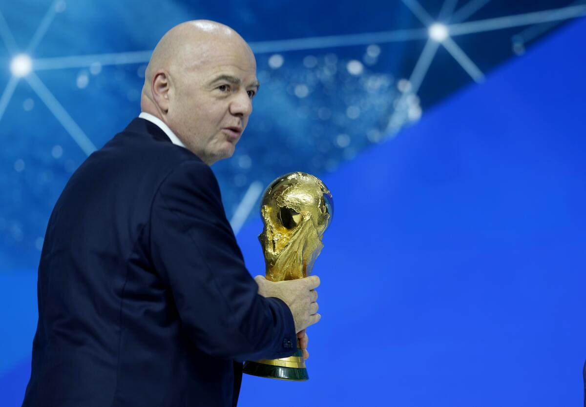 El presidente de la FIFA Gianni Infantino se retira con el trofeo de la Copa del Mundo.