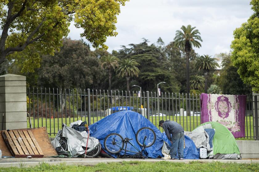 LOS ANGELES, CA-APRIL 6, 2020: Overall, shows a homeless encampment on San Vicente Blvd in Los Angeles, located just outside the grounds of the VA West Los Angeles Campus. The VA is opening the campus to camping by homeless veterans in a designated parking lot and also 2 sprung shelters that will have 25 beds in each. The VA had long rejected camping or more interim housing on the 388 acre campus saying vets had ample shelter space but Covid-19 pandemic reversed that position. (Mel Melcon/Los Angeles Times)