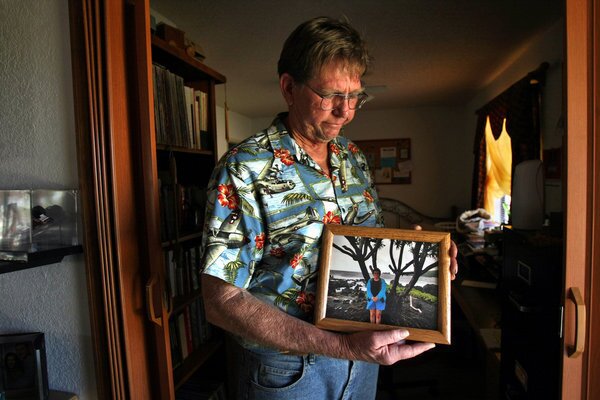 Ben Devitt holds a photo of his wife Pamela Devitt inside his home in Littlerock.