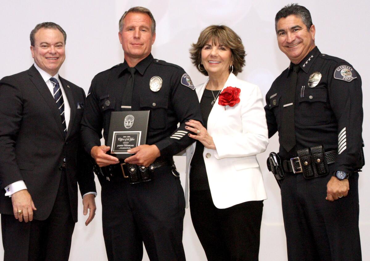 The 2016 Glendale Police Awards Officer of the Year award went to officer Jim Trudeau, second from left, with Kiwanis Club of Glendale president Jose Sierra, left, Glendale Mayor Paula Devine, second from right and Glendale Police Chief Robert Castro, right, at the Glendale Civic Auditorium on Thursday, May 12, 2016.