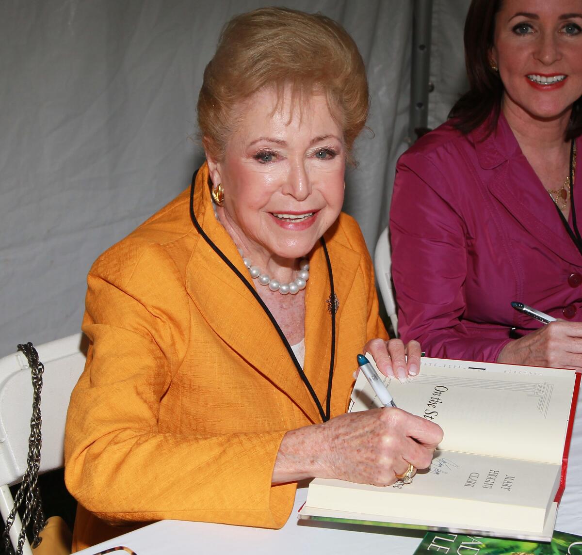Mary Higgins Clark, signing one of her books, and daughter Carol Higgins Clark at the 2011 L.A. Times Festival of Books.