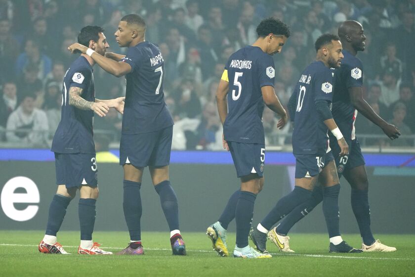 Lionel Messi (izquierda), celebra con Kylian Mbappe y con sus compañeros del PSG el primer gol del equipo en el partido de la League One francesa contra el Lyon, en el estadio Groupama, en Decines, a las afueras de Lyon, Francia, el 18 de septiembre de 2022. (AP Foto/Laurent Cipriani)