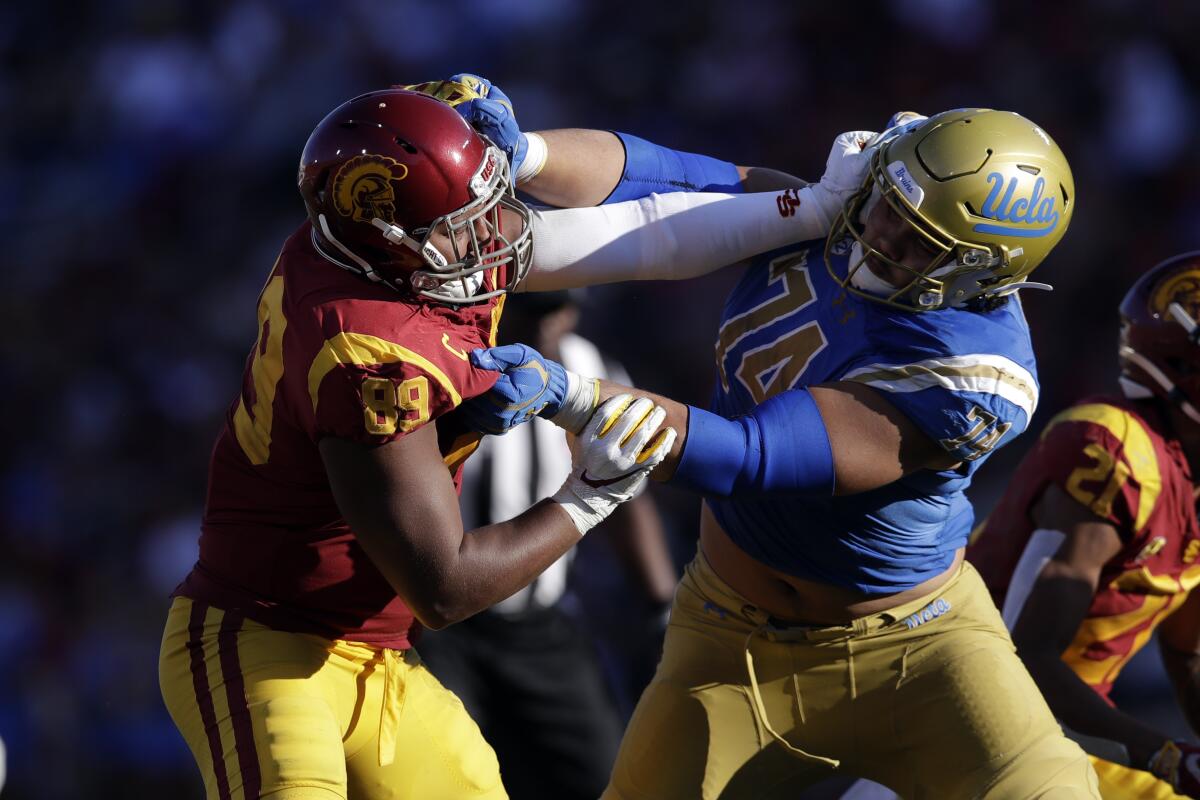 USC defensive lineman Christian Rector tries to get past UCLA offensive lineman Sean Rhyan.