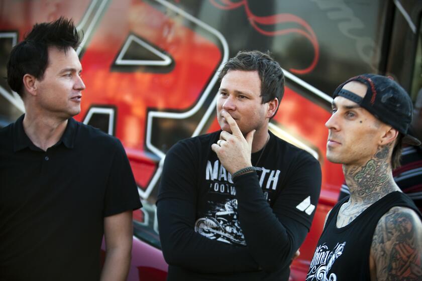 Blink-182 members: bassist/vocalist Mark Hoppus, left, guitarist/vocalist Tom DeLonge, center, and drummer Travis Barker, right, during a promotional contest before their concert at the Honda Center in Anaheim.