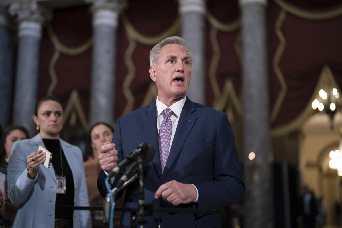 House Speaker Kevin McCarthy stands at a microphone.