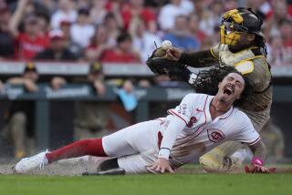 Cincinnati Reds' Jonathan India reacts as he collides with San Diego Padres catcher Luis Campusano during the second inning of a baseball game Tuesday, May 21, 2024, in Cincinnati. India was safe and Campusano was charged with an error. (AP Photo/Carolyn Kaster)