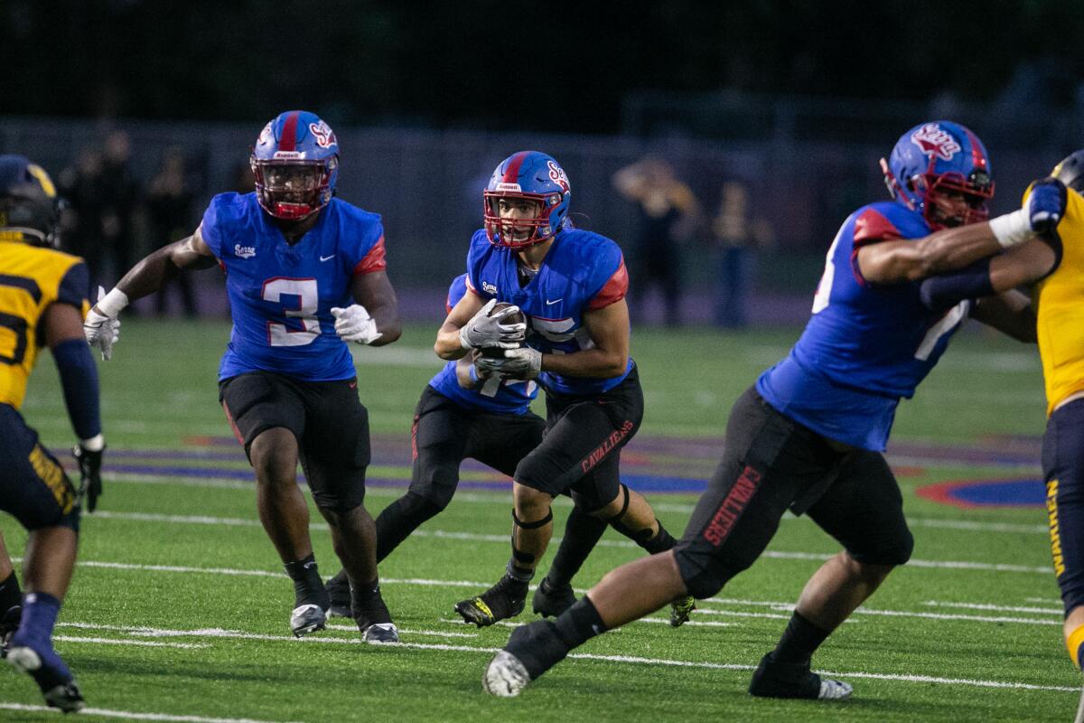 Sondheimer: Former Southland gamers steadiness faculty and soccer in Ivy League 1 Kai Honda (center) looks for room to run after taking a handoff while playing at Gardena Serra in 2022.