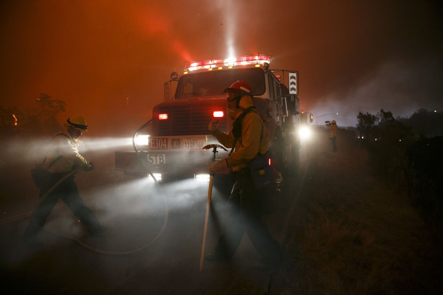 Firefighters make a defensive move on the front lines of the Sherpa Fire to avoid it from moving onto the 101 freeway, along Calle Real road, in Goleta, Calif.