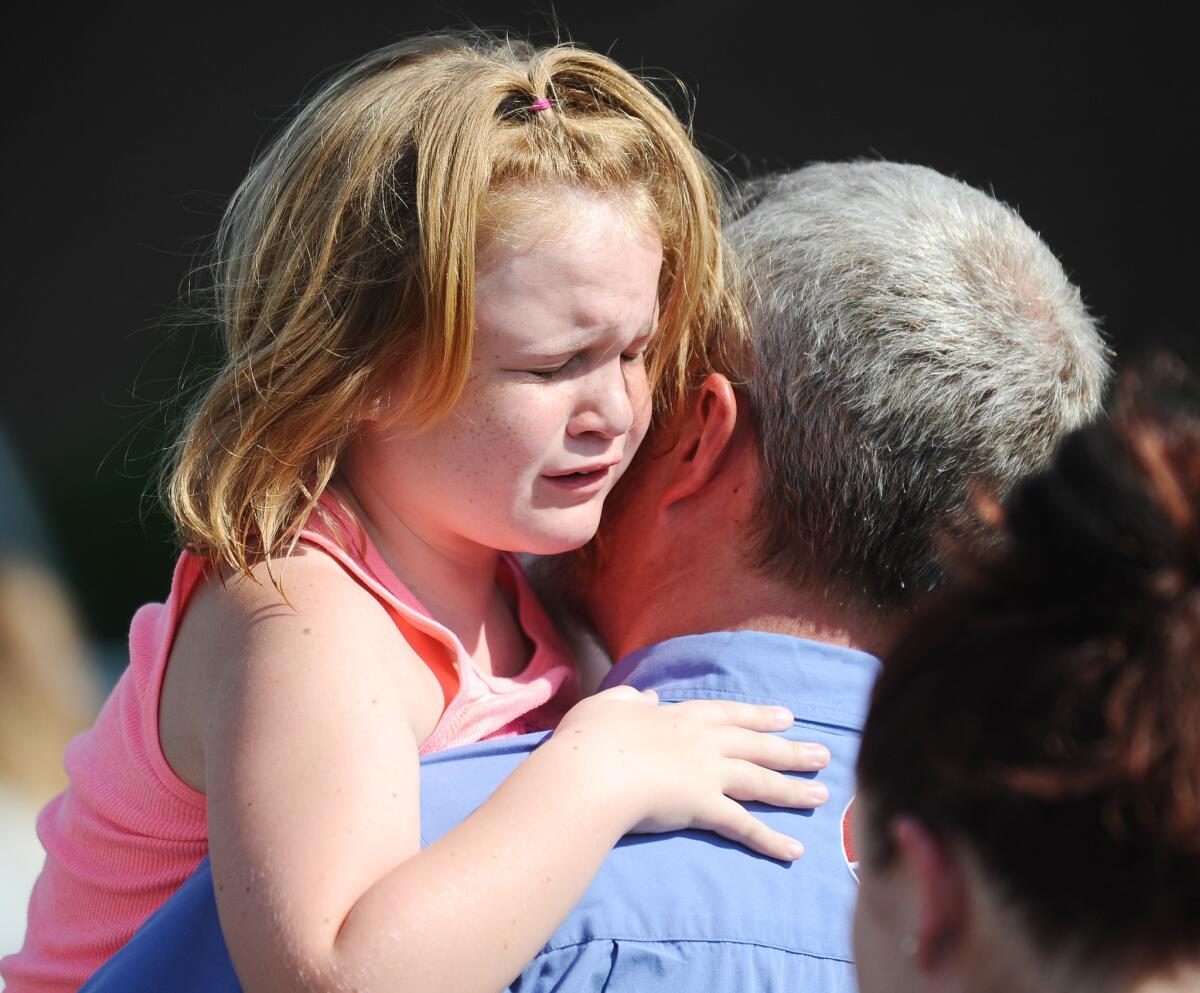 Lilly Chapman, 8, cries after being reunited with her father, John Chapman at Oakdale Baptist Church on Wednesday in Townville, S.C.