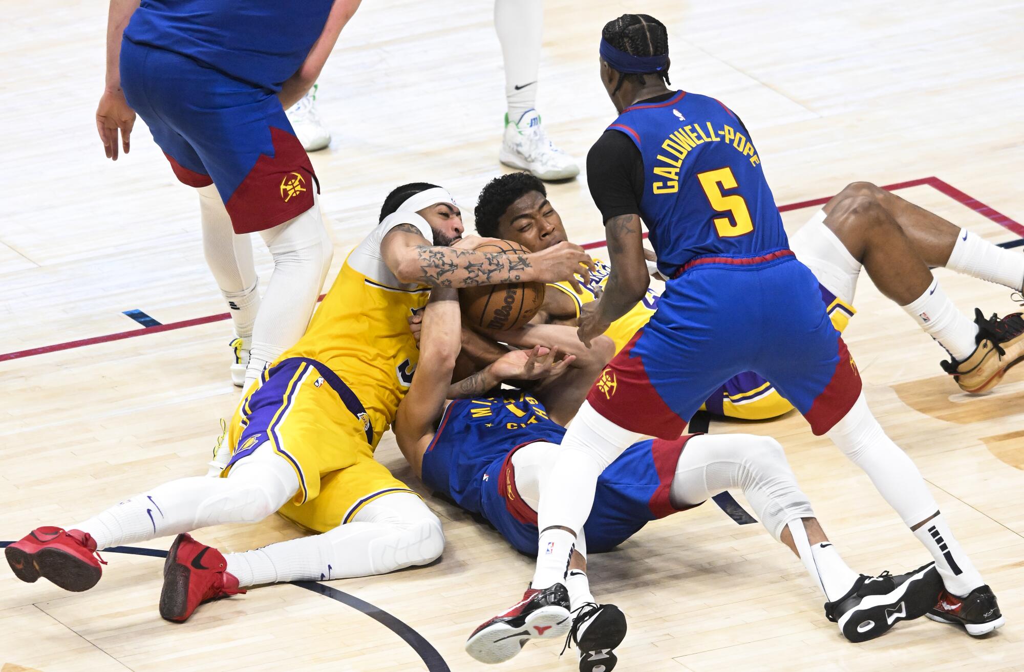 Nuggets forward Michael Porter Jr. battles for the loose ball against Lakers Rui Hachimura and Anthony Davis.
