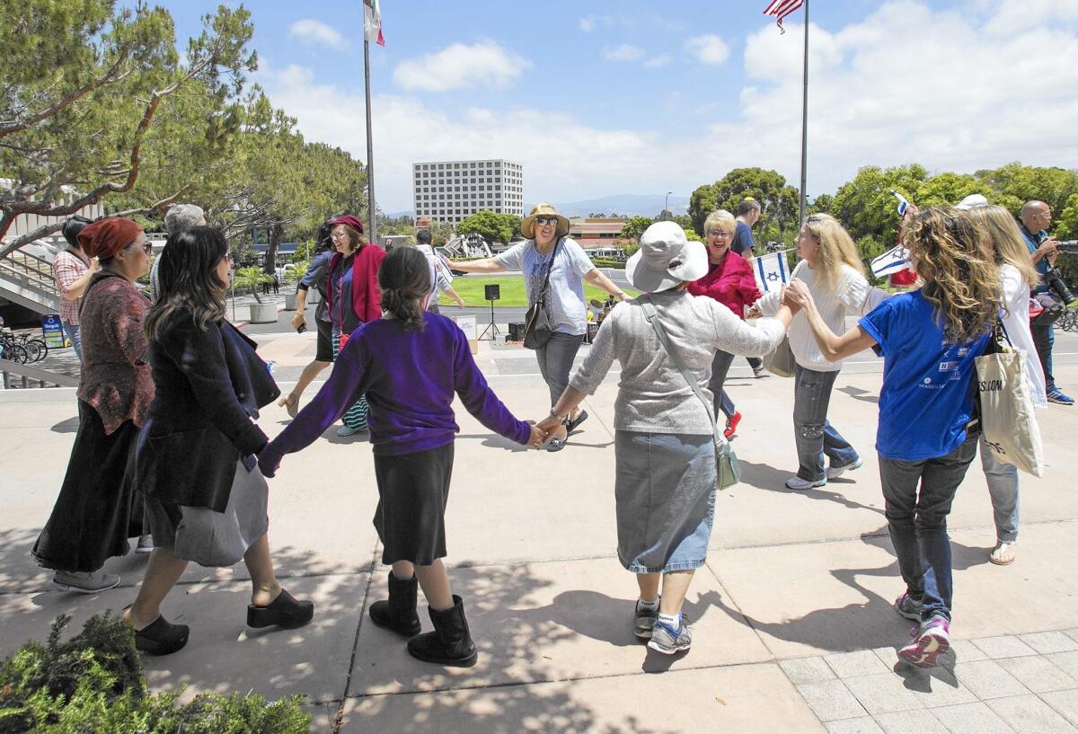 Supporters join hands during a pro-Israel rally Thursday at UC Irvine.