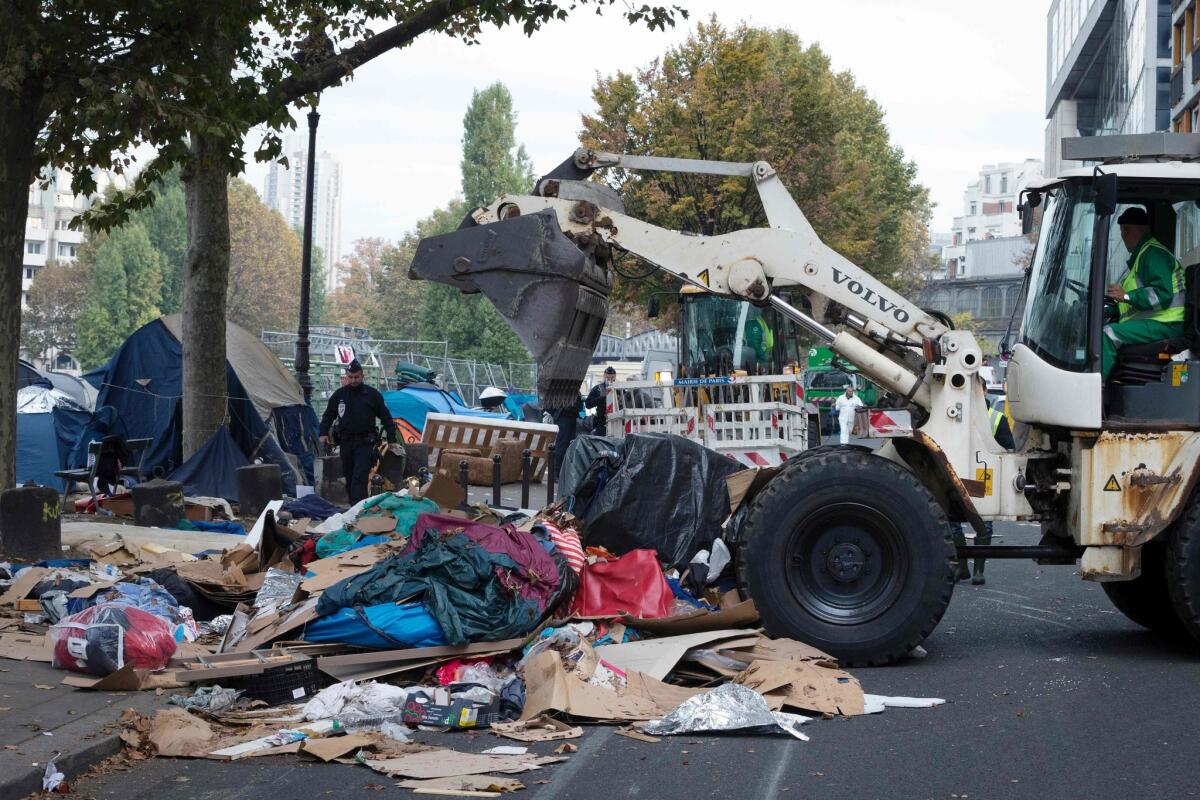 A bulldozer removes tents after an evacuation of a makeshift camp near Stalingrad metro station in Paris.