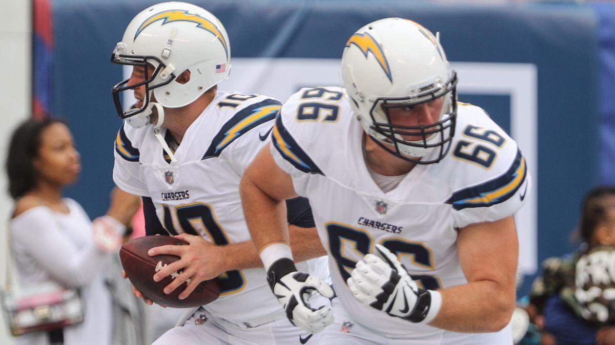 Chargers offensive guard Dan Feeney (66) and quarterback Kellen Clemens (10) warm up for their game on Oct. 8.