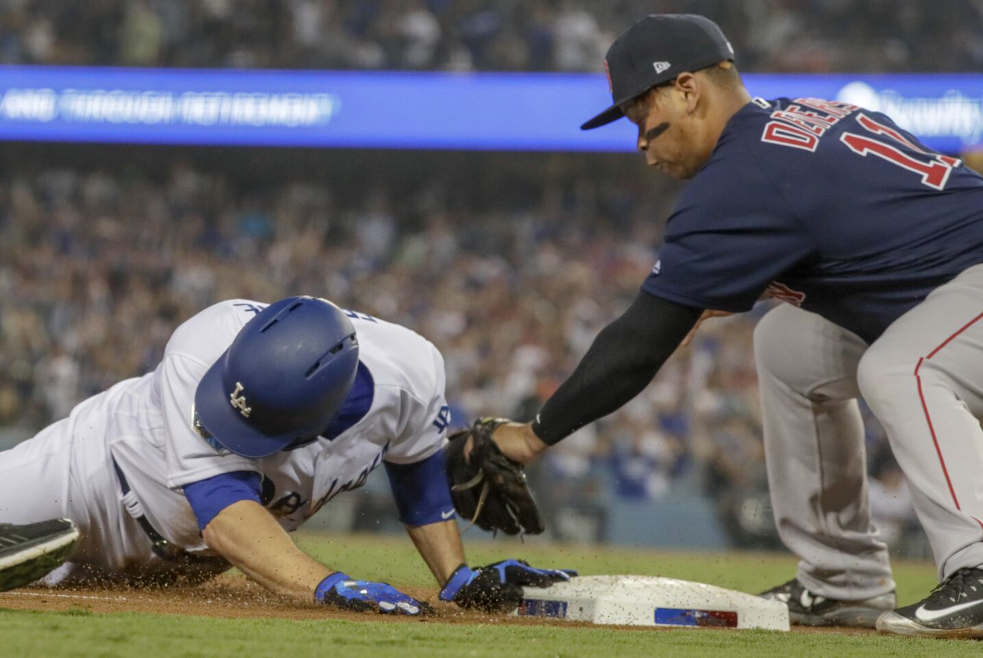 Dodgers David Freese slides into third with a third inning triple as Red Sox's Rafael Devers makes a late tag.
