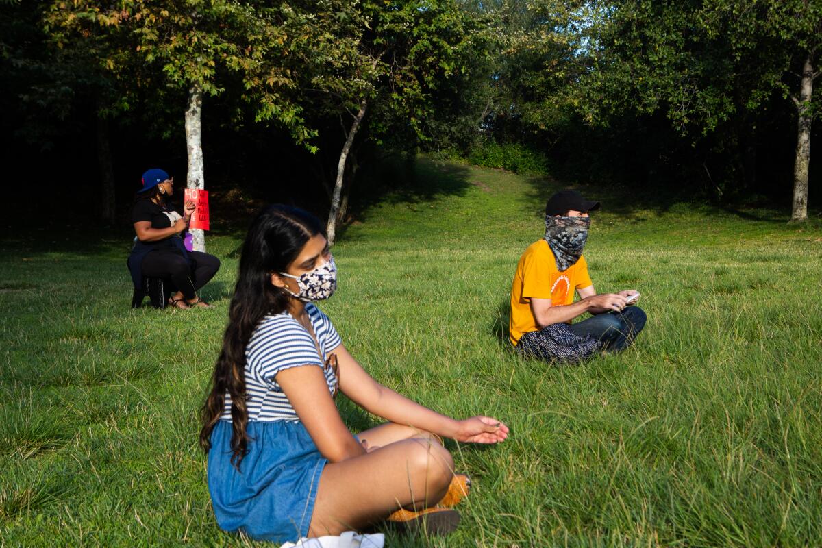 Parkgoers sit at a social distance in Vista Hermosa Natural Park on Tuesday.