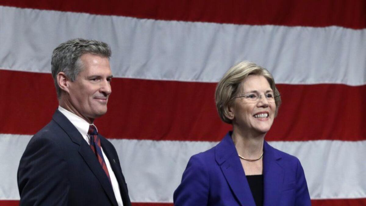 Former Massachusetts Sen. Scott Brown, a Republican, leaves the stage with Elizabeth Warren, the Democrat who defeated him, after a 2012 debate in Springfield, Mass.
