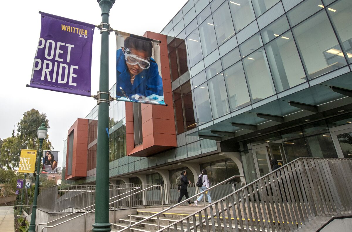 Students walk into a building at Whittier College.