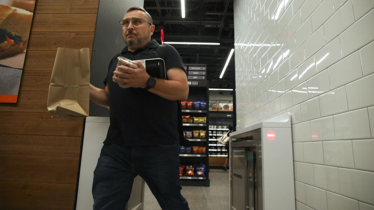 A shopper leaves an Amazon Go store in Chicago with his purchases in September.