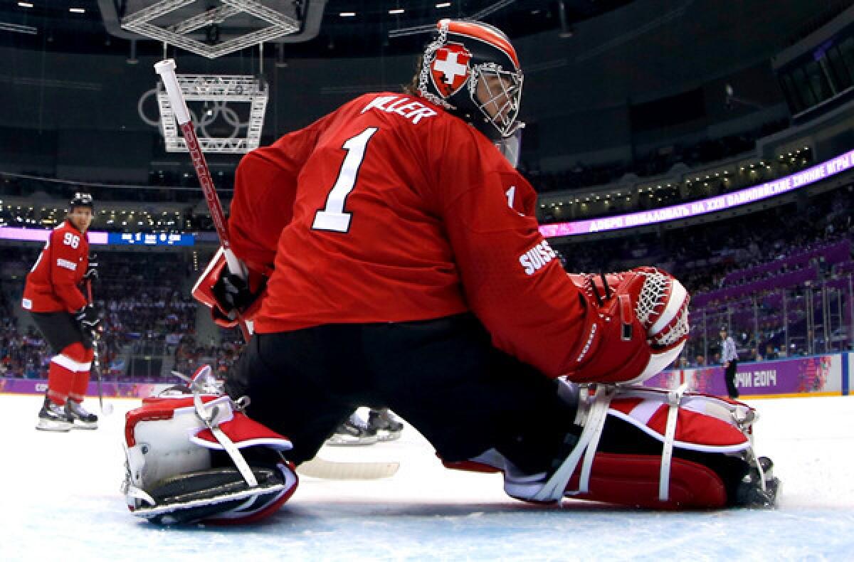 Switzerland goalkeeper Jonas Hiller deflects a shot by the Czech Republic during a 1-0 victory on Saturday in a preliminary-round game at the Sochi Olymics.