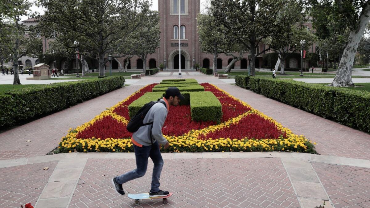 A student skateboards on the USC campus outside Bovard Hall.