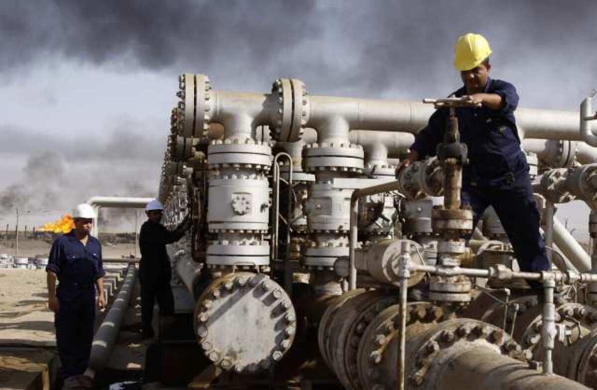 In this 2009 photo, Iraqis work at the Rumaila oil refinery near Basra. The International Energy Agency predicted that Iraq will continue to grow as a global oil power.