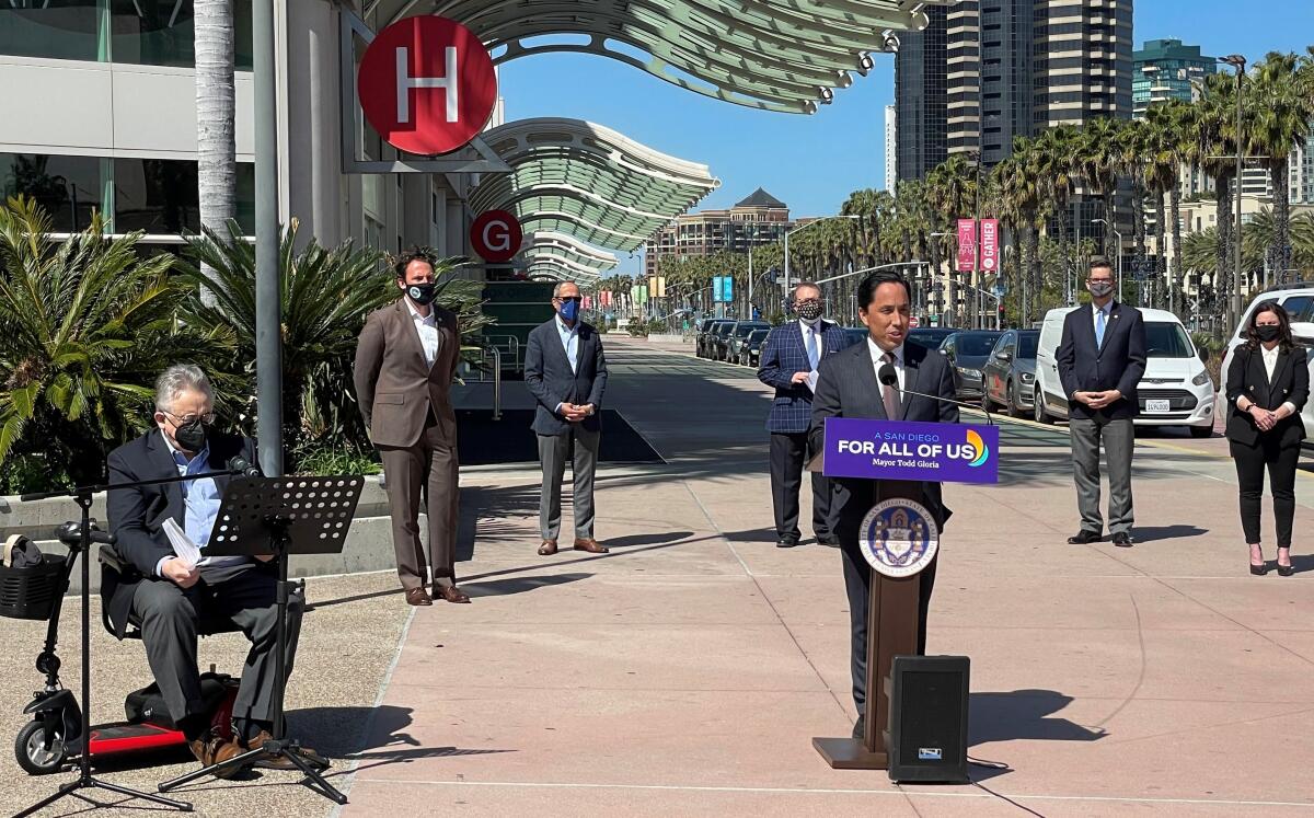 San Diego Mayor Todd Gloria speaks at a lectern outside the San Diego Convention Center.